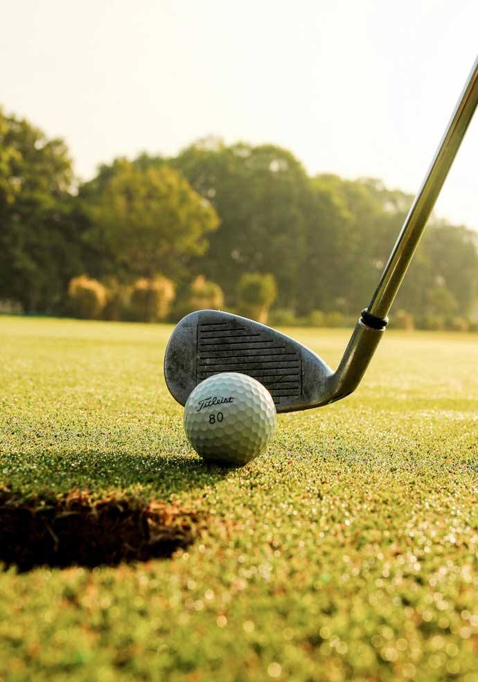 A close up image of a golf ball about to be putted in a golf hole.