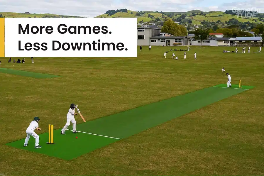 Cricket match on multiple outdoor turf pitches in school ground.