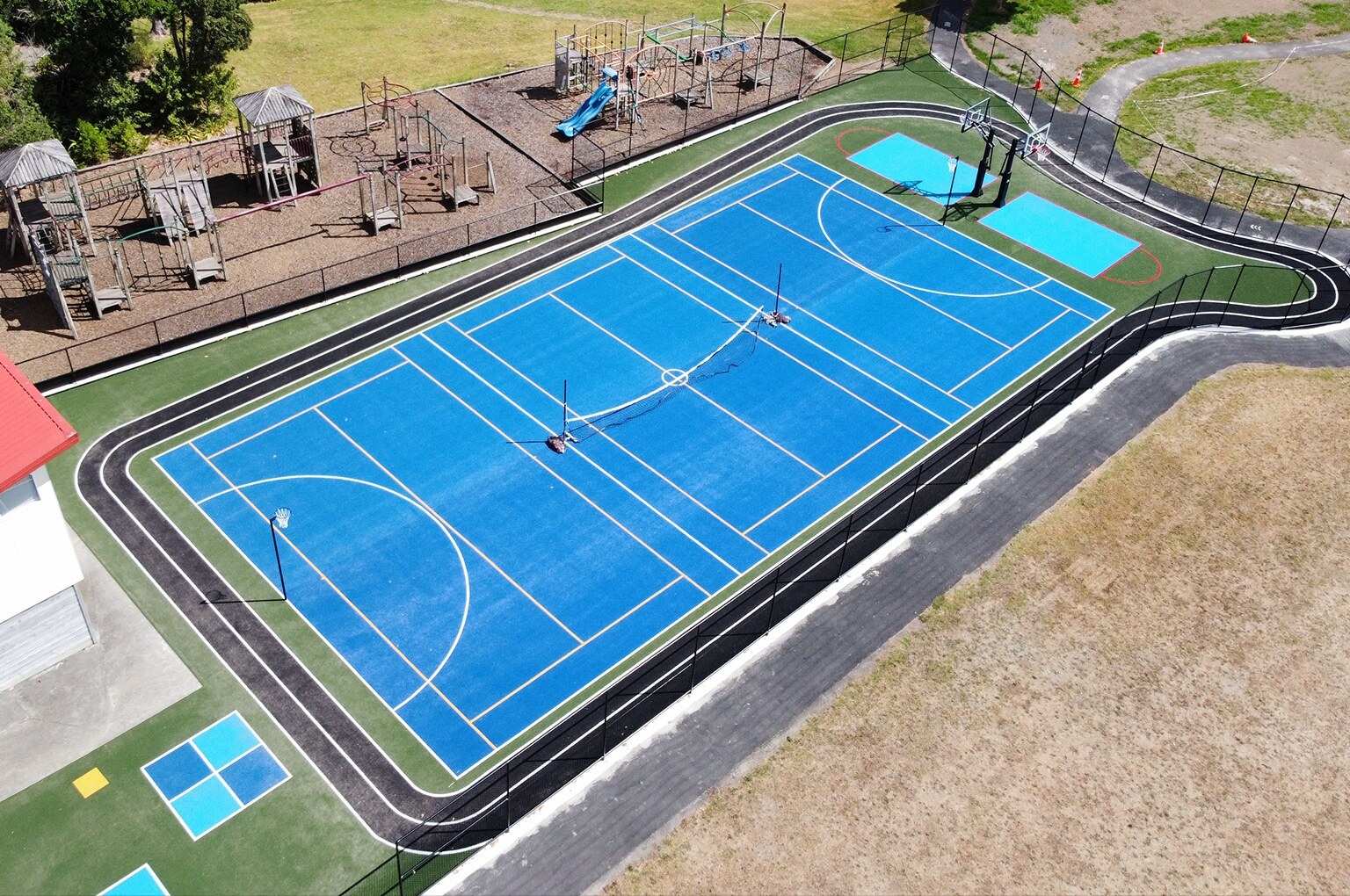 New multi-sport court with artificial turf by Game On Turf in Auckland, New Zealand, featuring basketball, netball, and running track.